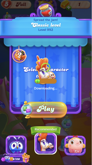 Écran avant le niveau dans Candy Crush Friends Saga montrant 'Étalez la confiture ! Niveau classique 992' avec Misty en cours de téléchargement pour la sélection et un bouton 'Jouer',